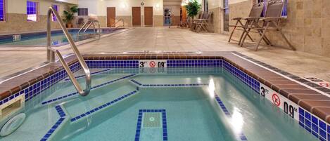 An indoor swimming pool with a 3 FT depth marker, lounge chairs, and a tiled floor.