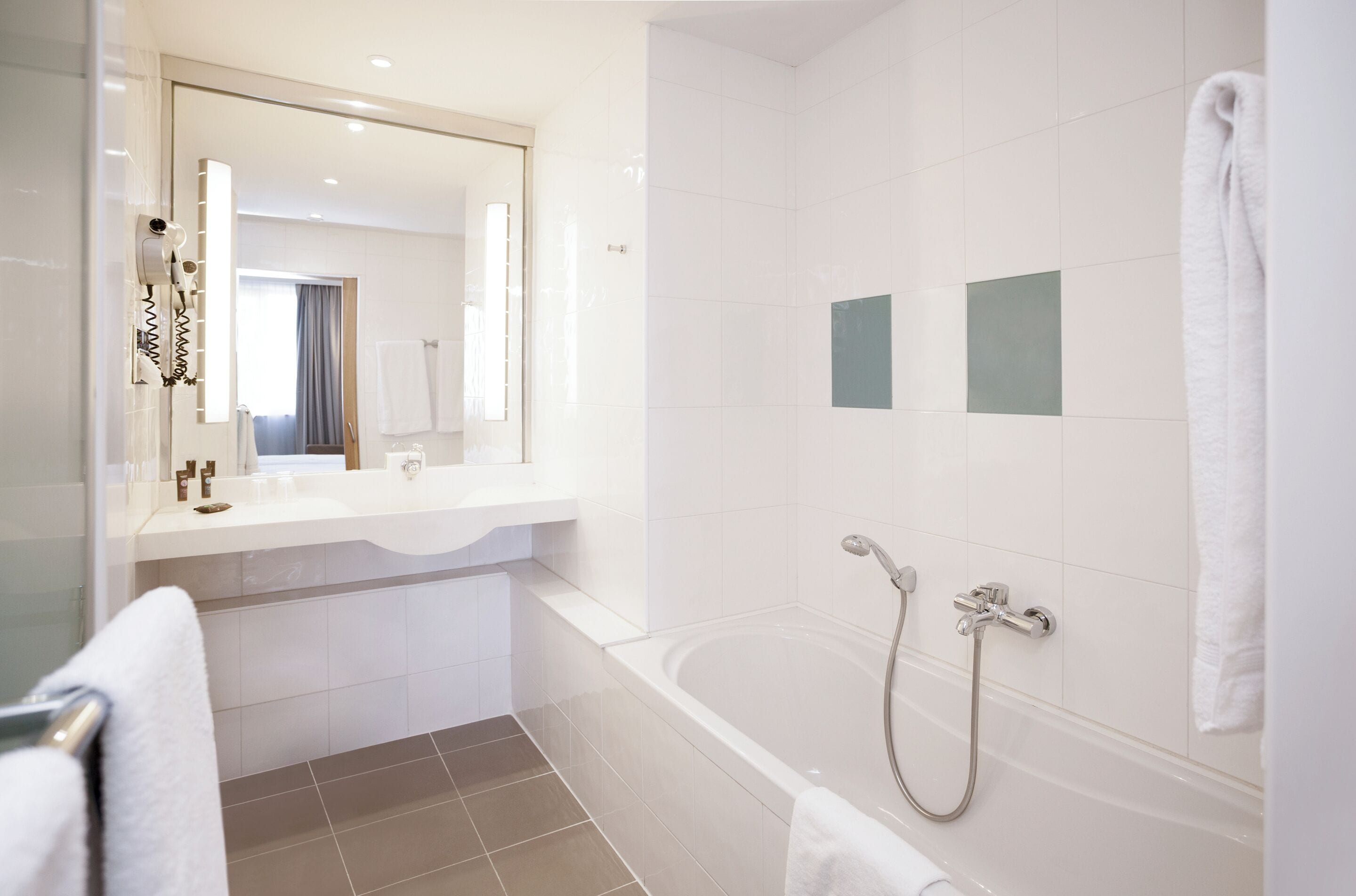 Un baño moderno con bañera, ducha y tocador con espejo.