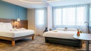 A hotel room with two beds, a desk, and a chair with wheels.