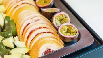 A tray of sliced fruits and passion fruit halves.