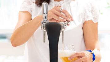 A person pouring beer from a tap into a glass.