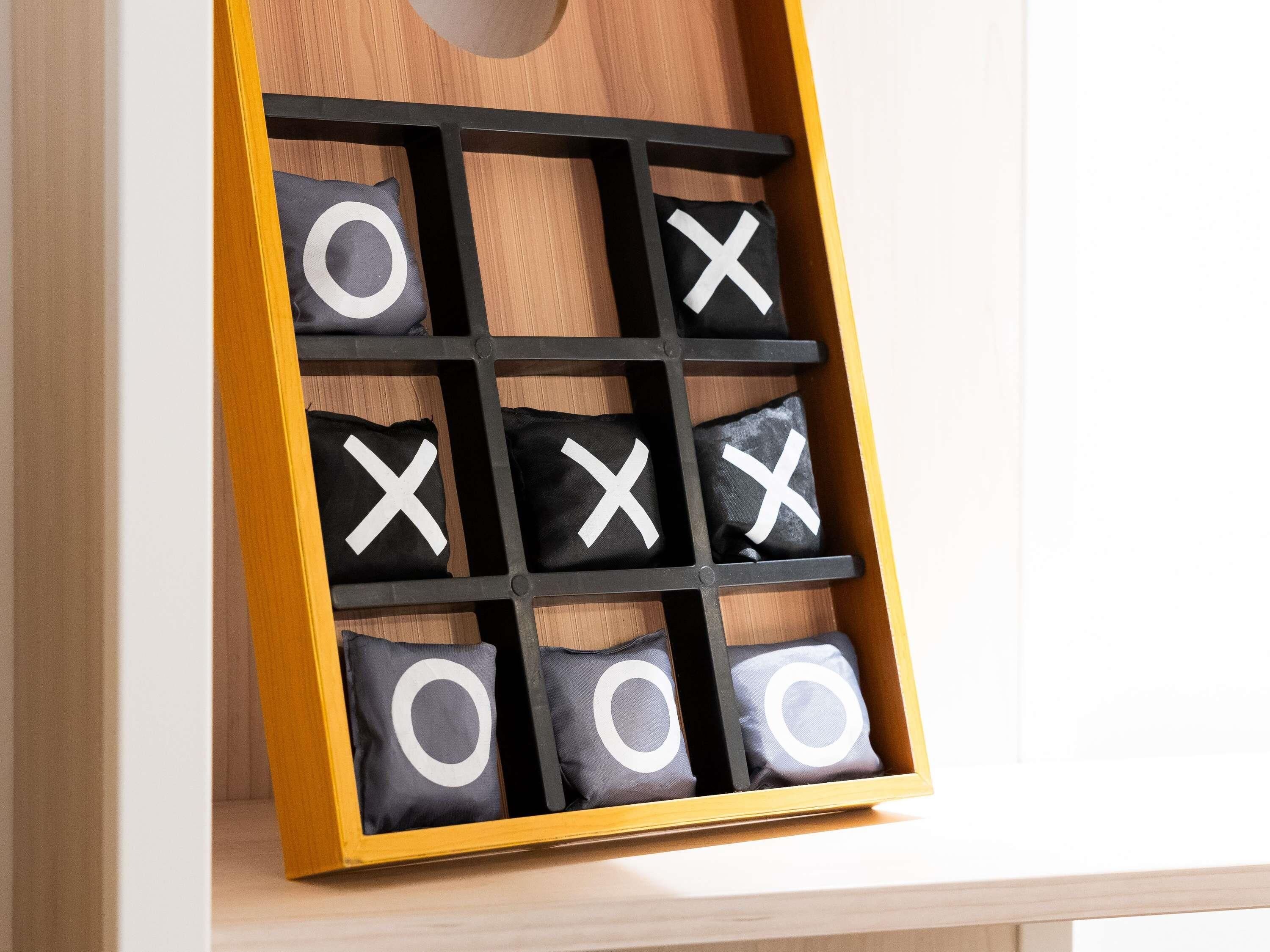 A storage box with compartments containing pillows marked with 'X' and 'O'.