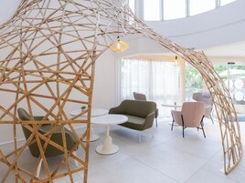 Un interior moderno con una estructura única de bambú, asientos cómodos y un ambiente luminoso y espacioso.