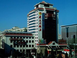 A multi-story building with a prominent vertical sign on the facade.