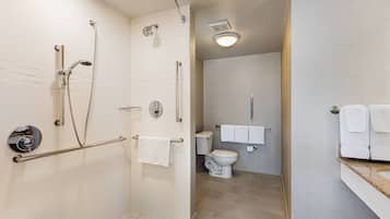 Un baño moderno con cabina de ducha, inodoro y lavabo.