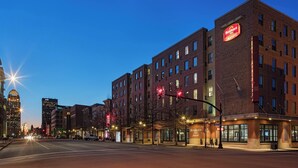 A hotel with a brick facade, multiple floors, and a prominent signage.