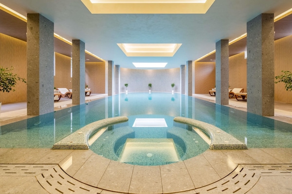 Una piscina techada, sillones reclinables de piscina