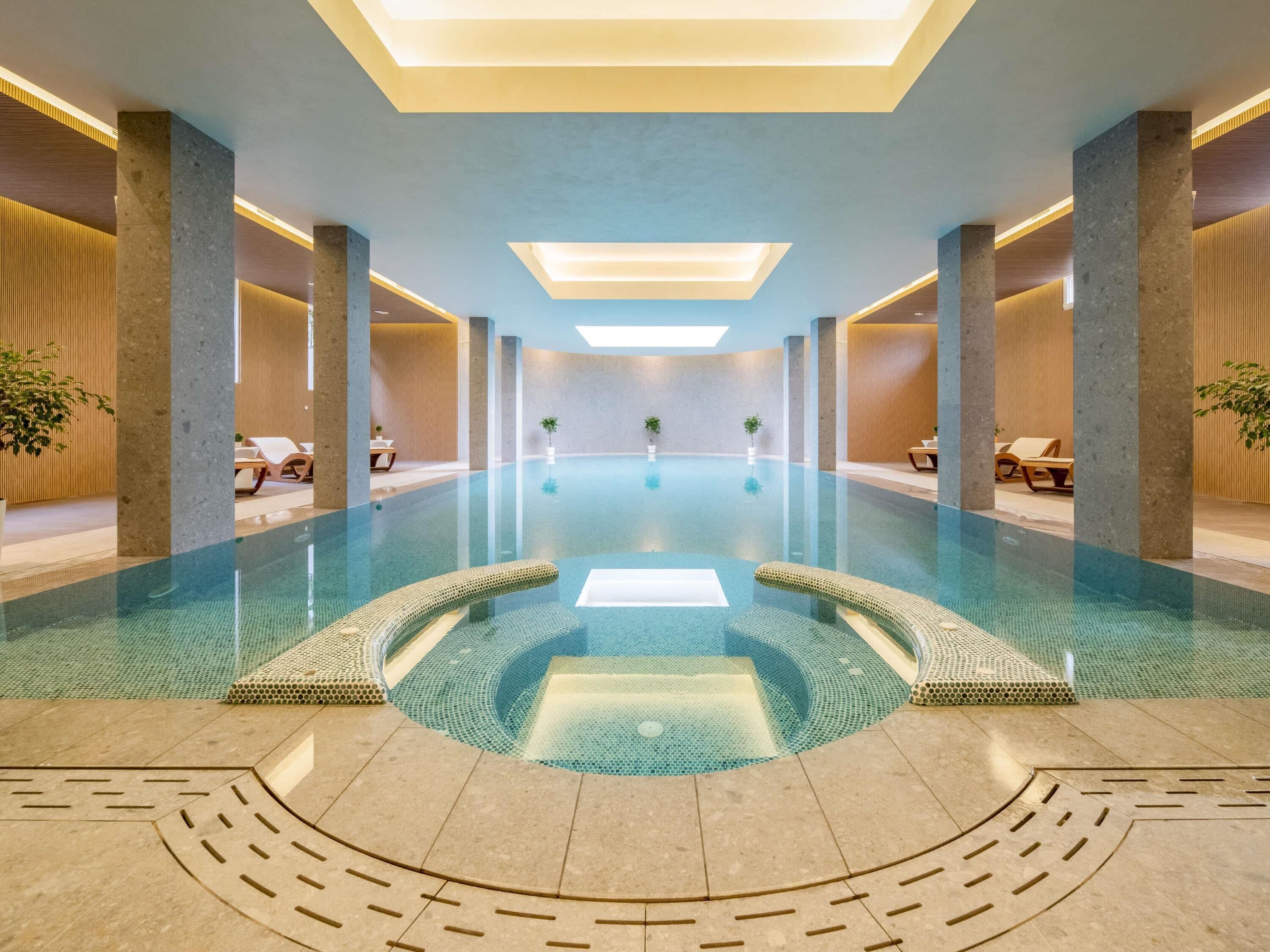 Una piscina techada, sillones reclinables de piscina