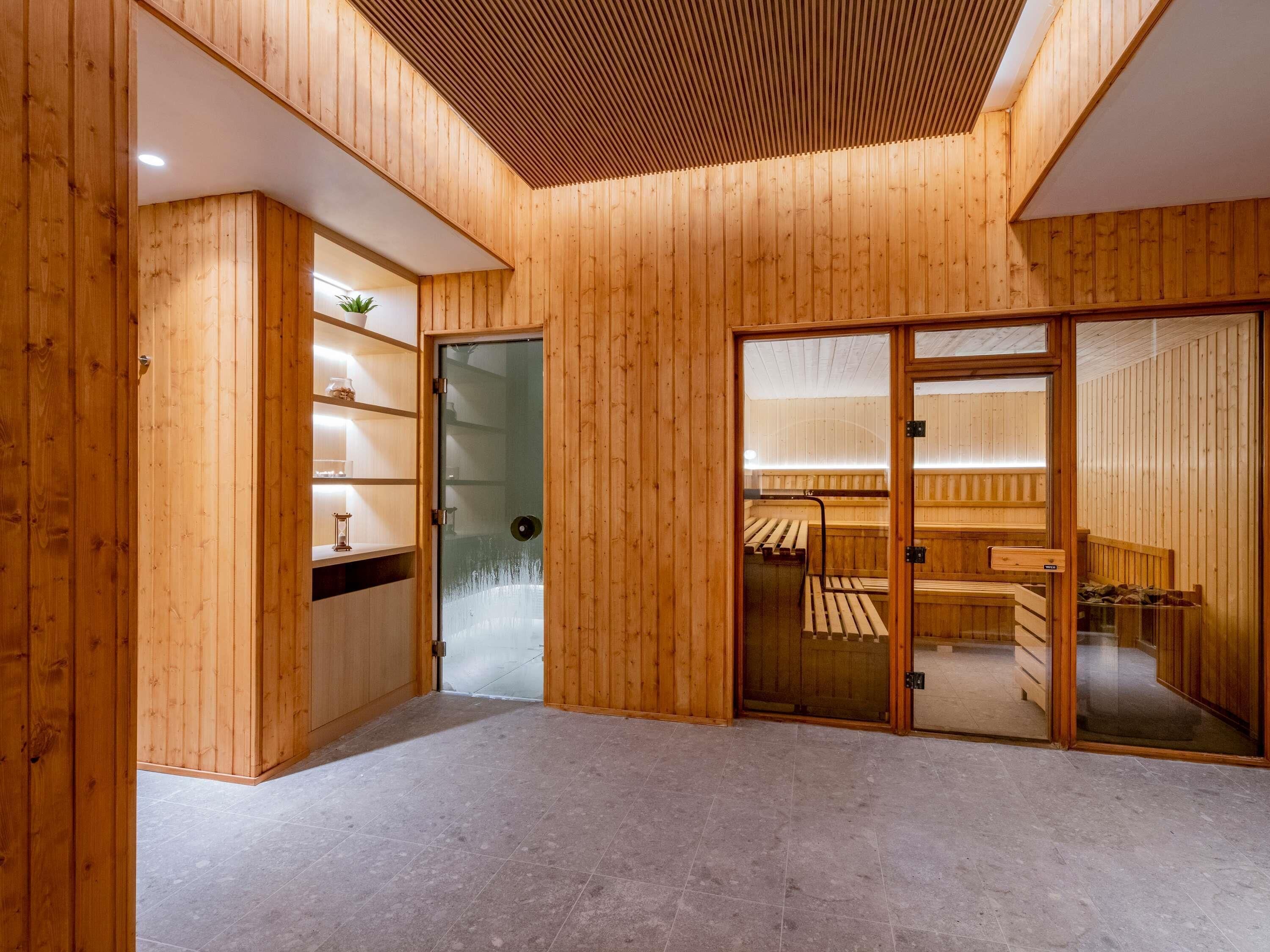 A wooden interior with a glass door leading to a sauna area.