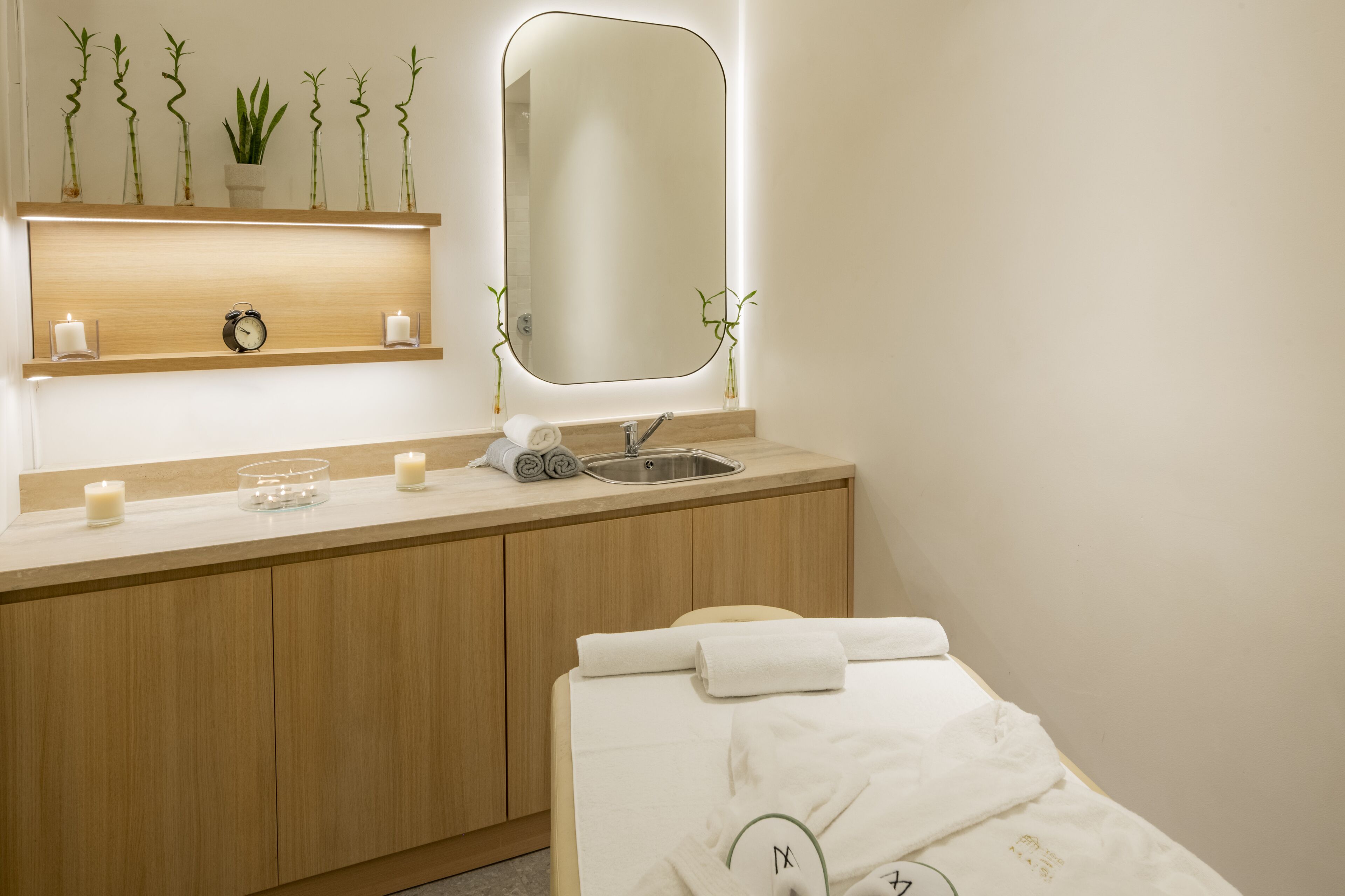 A modern bathroom with a wooden vanity, a mirror, a sink, and a towel rack.