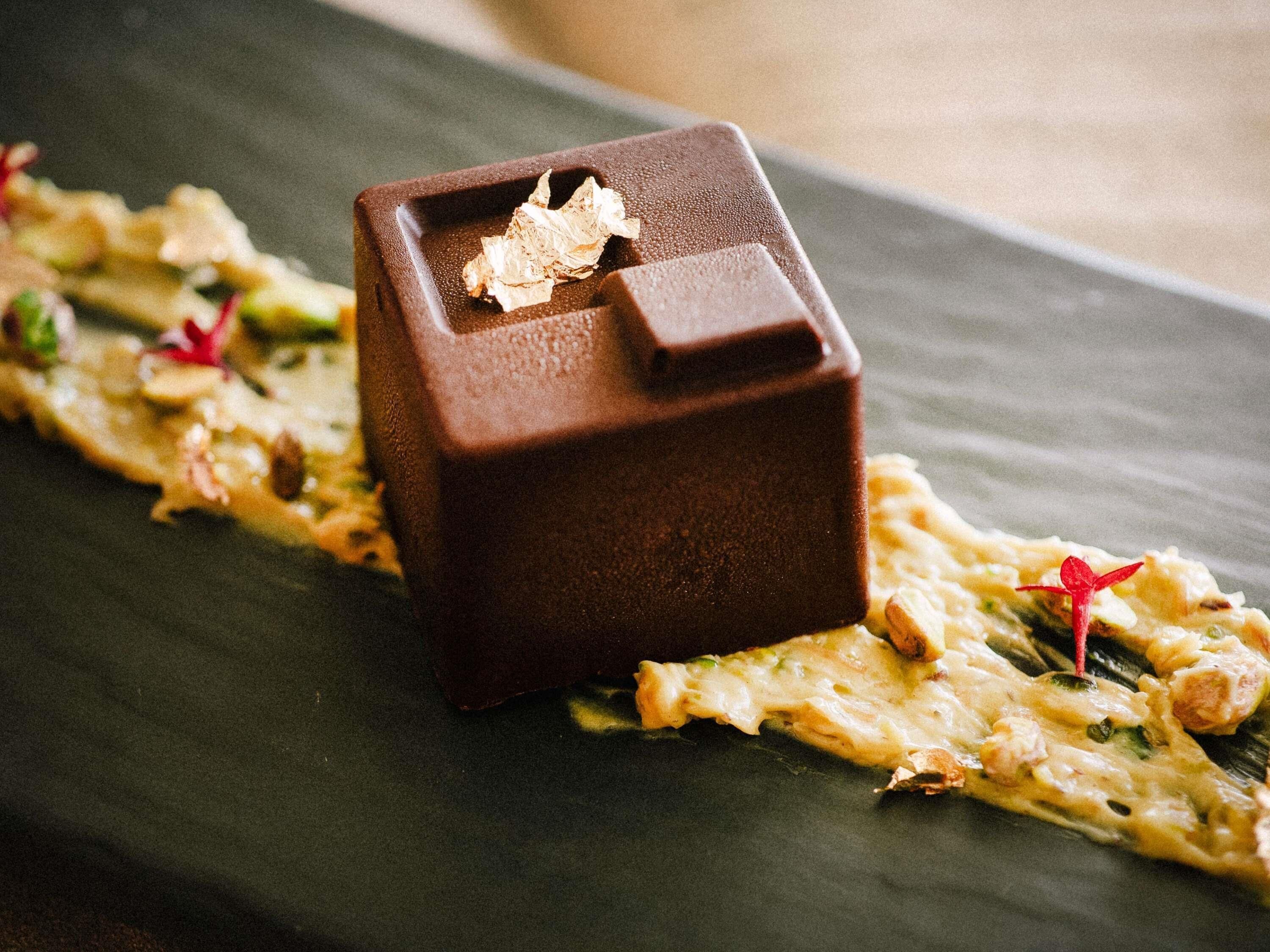 A chocolate dessert on a slate plate with a decorative arrangement.