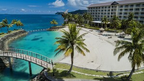 Un resort con playa, palmeras y vista despejada del océano.