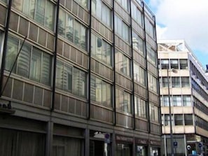 A multi-story building with large windows and a visible storefront at the ground level. - Hotel Commodore (Rome)