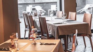 A restaurant with a table set for two, including wine glasses and cutlery. - Apartaments Shusski by Nexta. (Encamp)