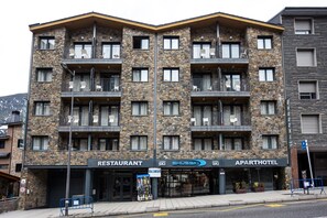 A multi-story building with a restaurant, a ski shop, and an apartment hotel.
