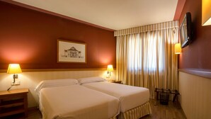 A hotel room with two beds, a television mounted on the wall, a framed picture, and a window with curtains. - Apartaments Shusski by Nexta. (Encamp)