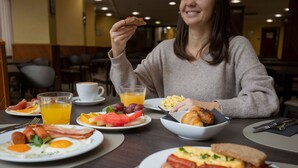 A breakfast setting with various dishes including eggs, bacon, toast, and fruit.