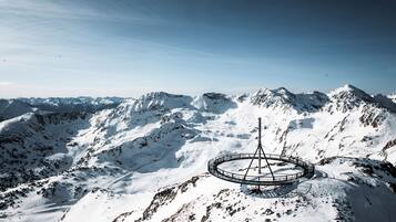 A snow-covered mountain with a circular viewing platform and a tall structure.