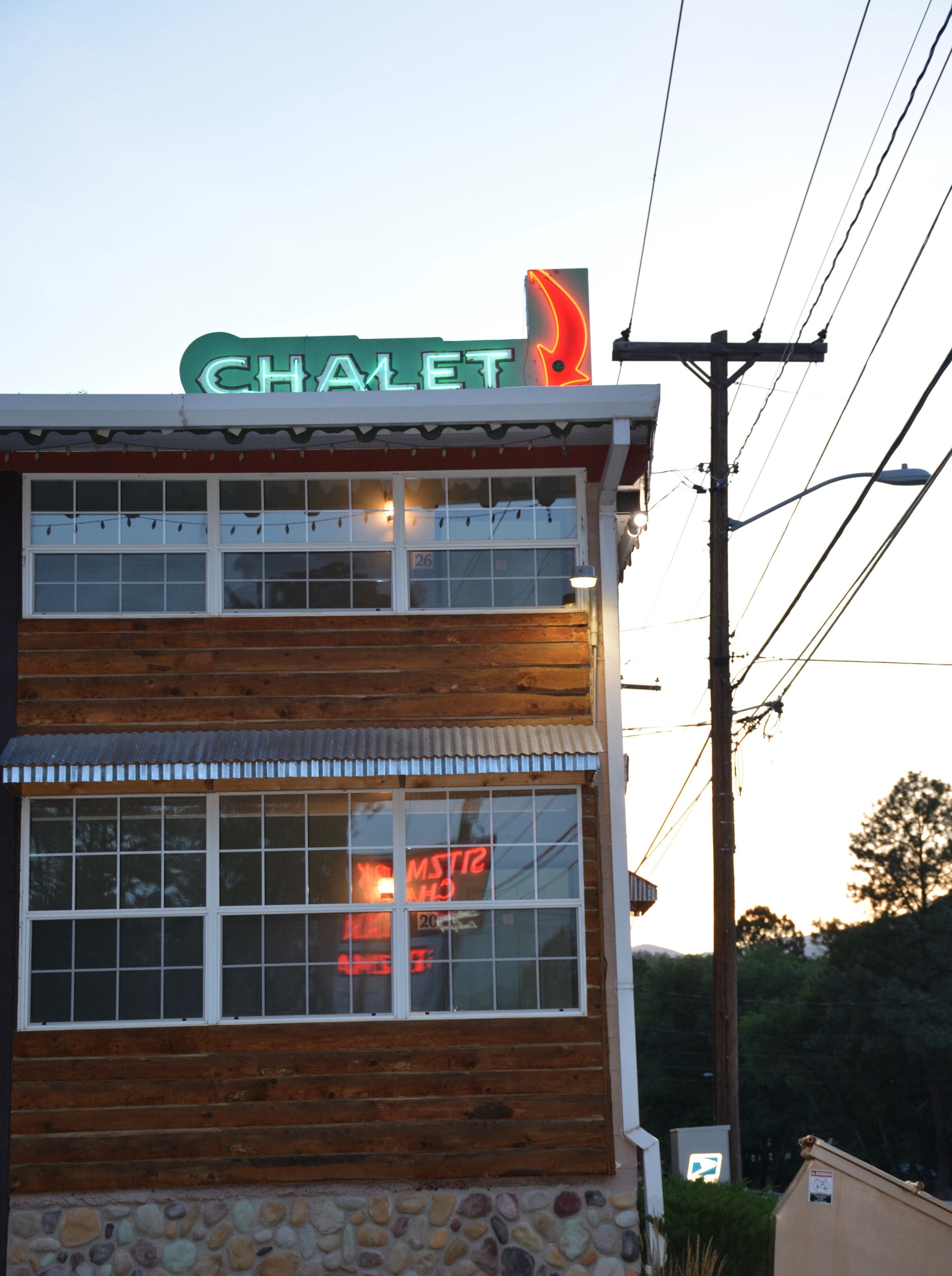 A two-story building with a sign reading "CHALET" on the top.