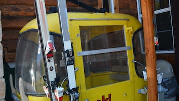 A yellow ski lift with the text "ski apache" on it, attached to a wooden building.