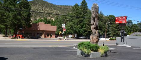 A parking lot with a stone sculpture, a building with a 'Sitzmark Chalet Inn' sign, and a mountain in the background.