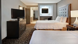 A hotel room with two beds, a television, a desk with a lamp, and a minibar. - Homewood Suites by Hilton Edgewater (Edgewater)