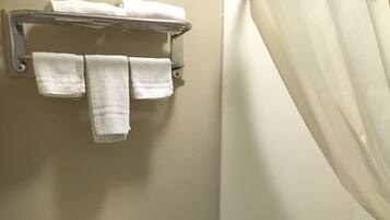 A bathroom with a toilet, a bathtub, and a towel rack with towels.