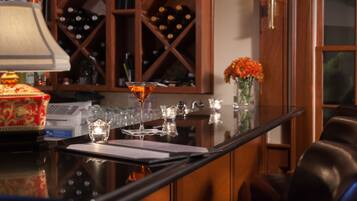 A bar area with a wine rack, a vase with flowers, and a martini glass on a reflective surface.