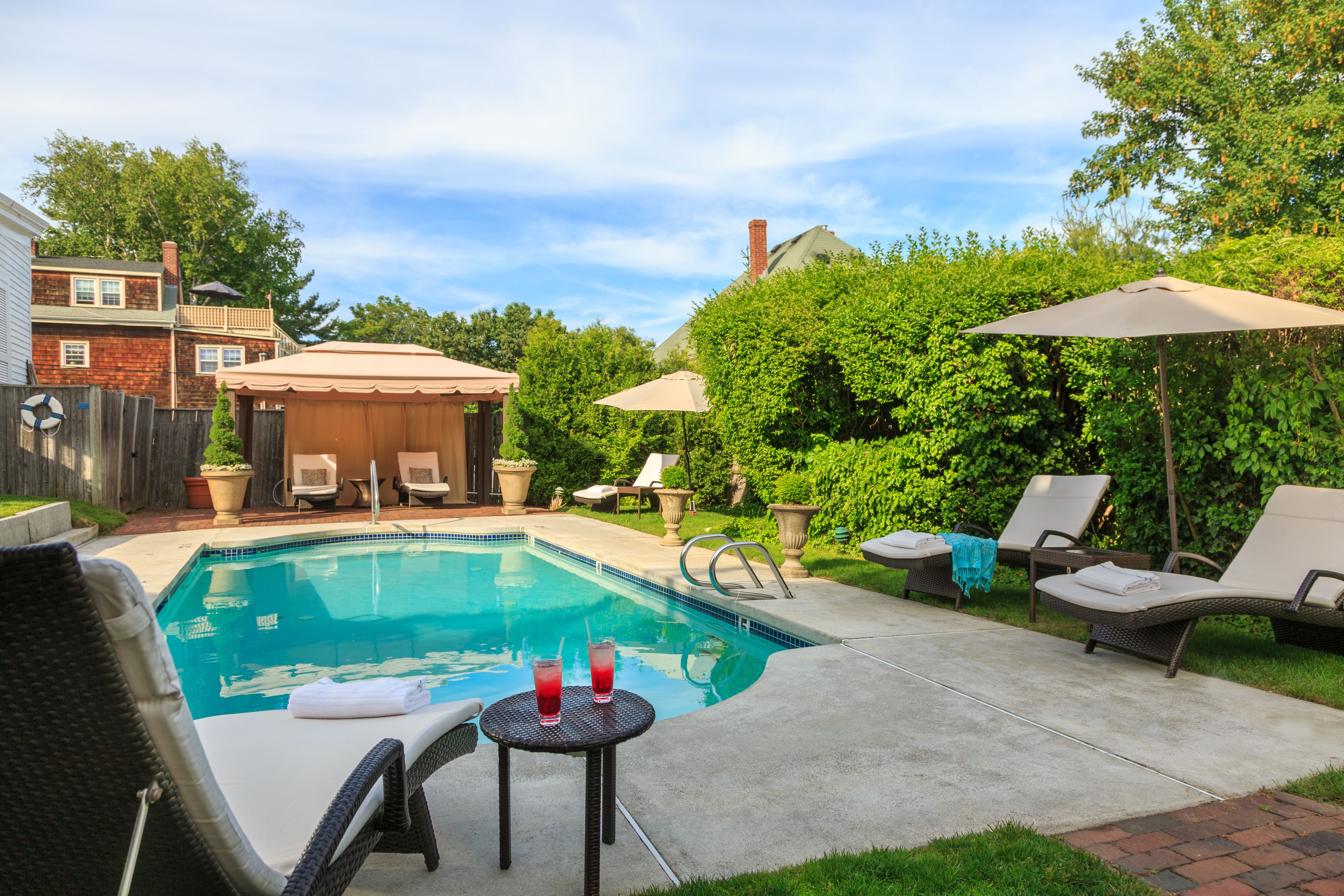 Una piscina al aire libre, sillones reclinables de piscina