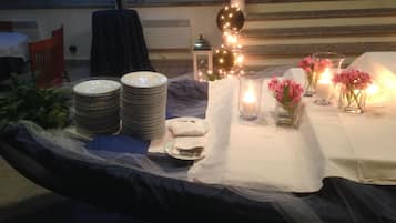 A dining setup with plates, candles, and flowers on a table.