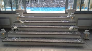 A set of stone steps leading to a pool area, with lanterns and flowers placed on each step.