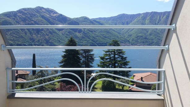 Un balcón con vista a un lago y montañas.