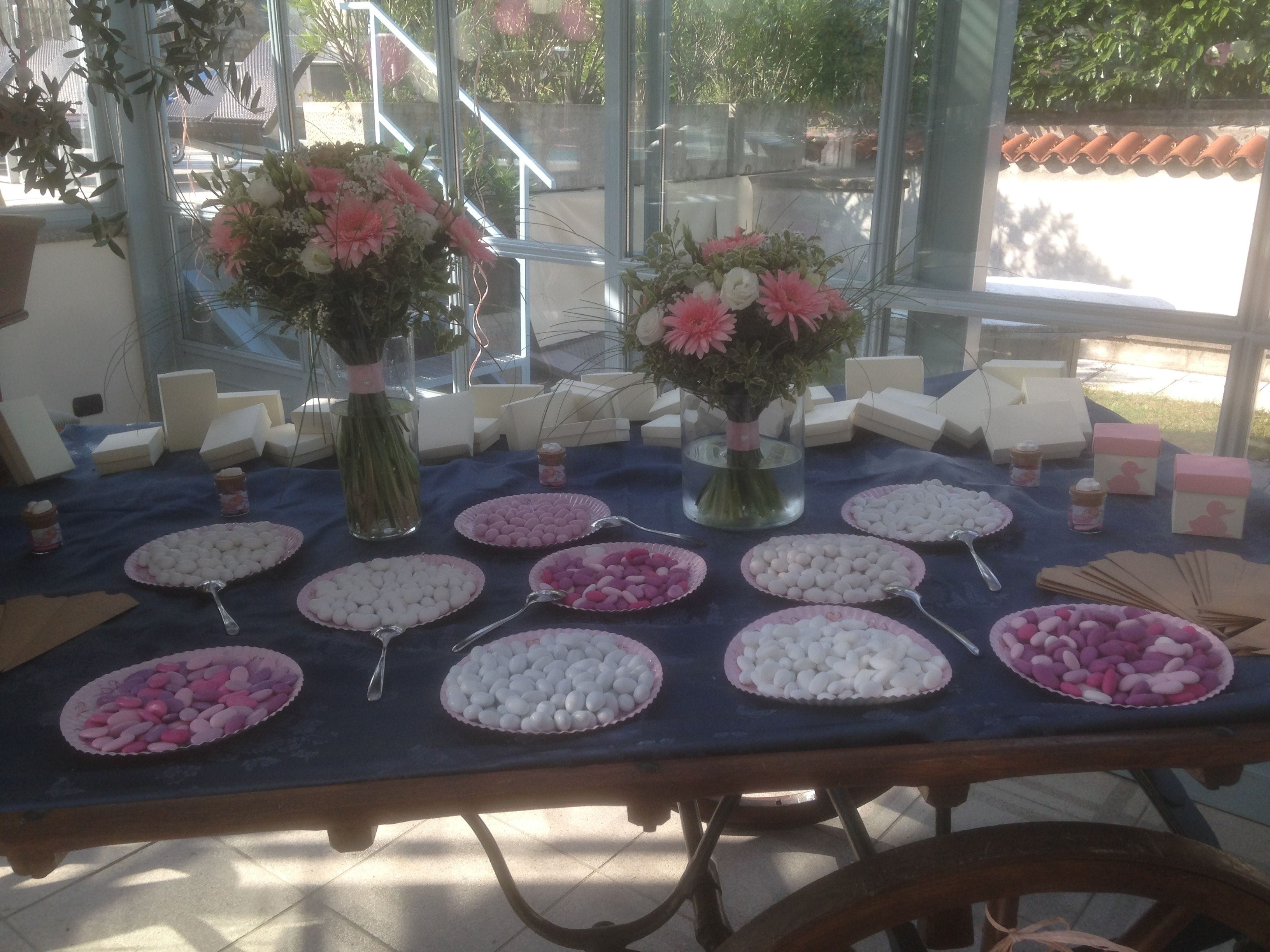 Ein Tisch mit verschiedenen Speisen und zwei Blumenarrangements.