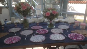 Une table avec divers aliments et deux compositions florales.
