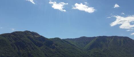 A mountainous landscape with a lake in the foreground and a clear sky.