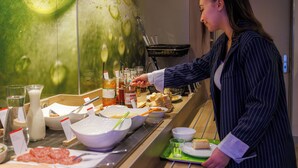 A buffet setup with various food items and condiments. - Hôtel ibis budget Aix-les-Bains Nord (Gresy-sur-Aix)