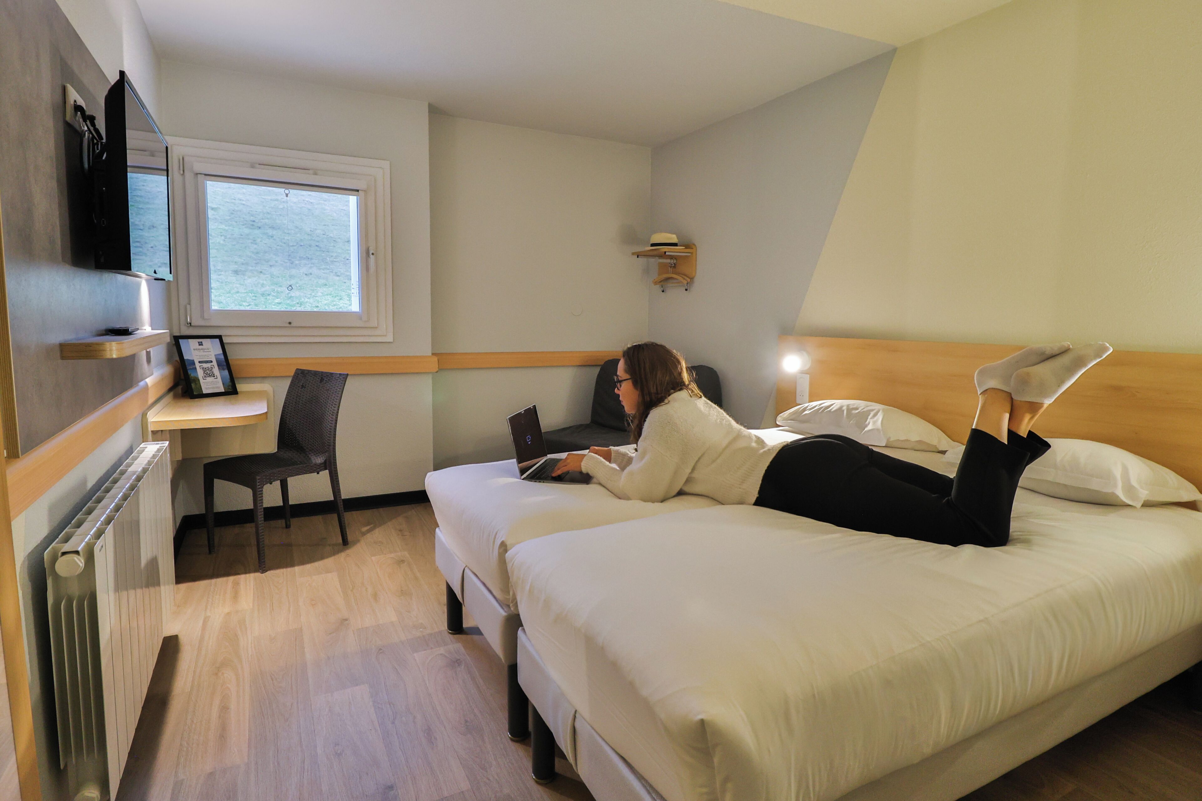 Una habitación con cama, escritorio, silla y ventana.
