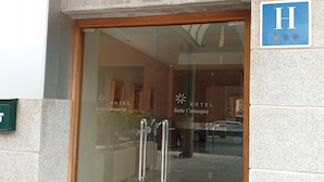 The entrance to Suite Camarena Plaza Hotel with a glass door and a sign above it. - Hotel Suite Camarena (Teruel)