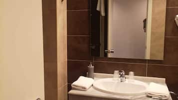 Un bany modern amb un doble lavabo, un mirall i una barra de tovalloles.
