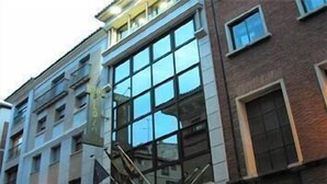 Un edificio de varios pisos con amplios ventanales y fachada de ladrillo.