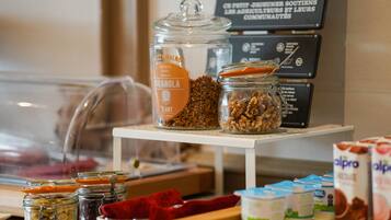 A breakfast bar with various food items including granola, nuts, and yogurt.