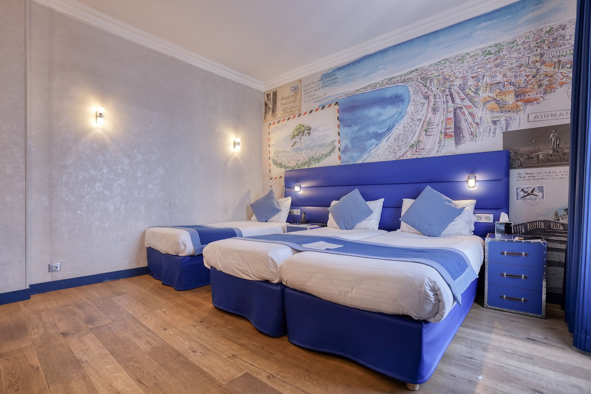 A bedroom with a large bed, two smaller beds, a nightstand, and a dresser.