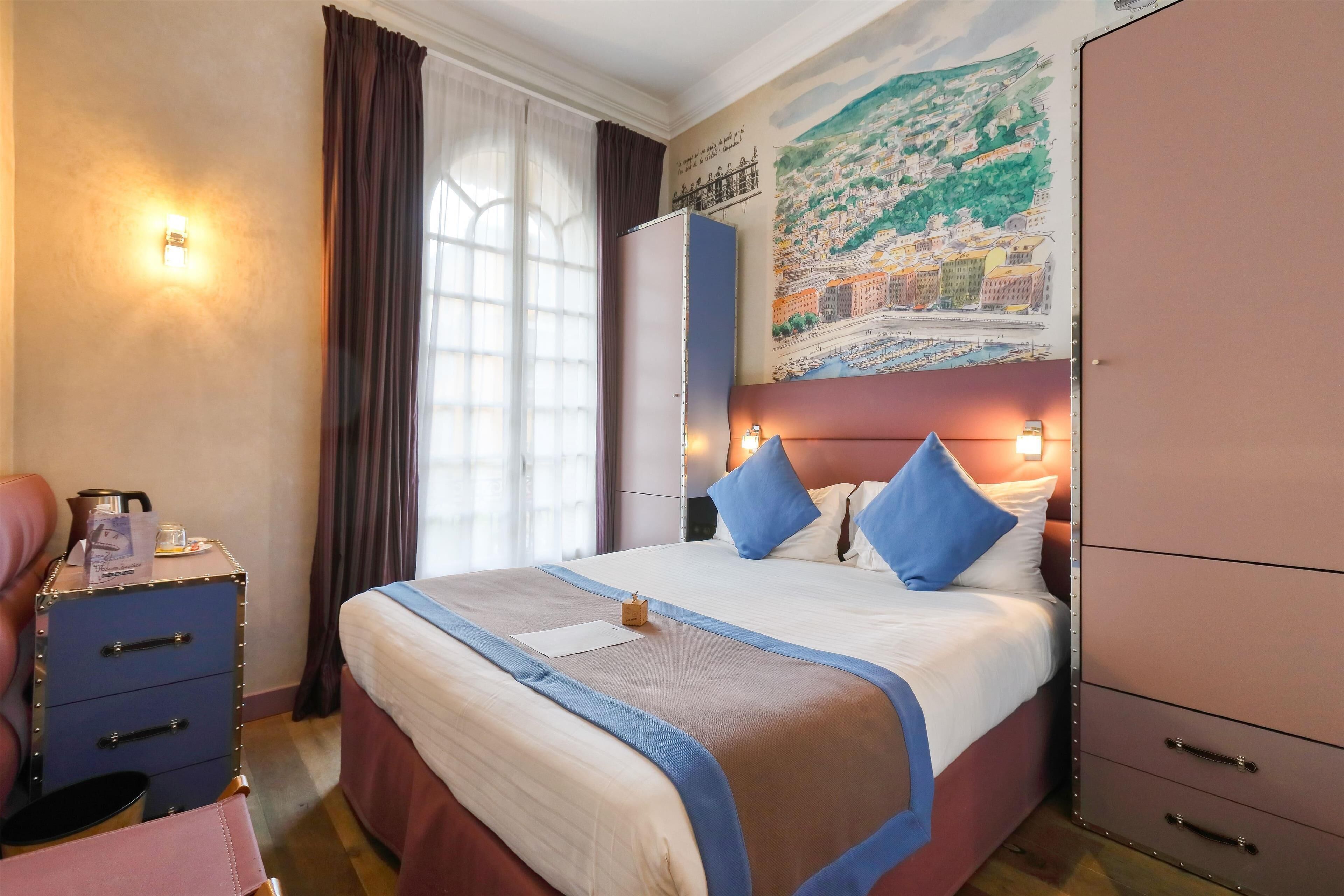 Una habitación de hotel con una cama grande, un armario, un escritorio con silla y una ventana con cortinas.