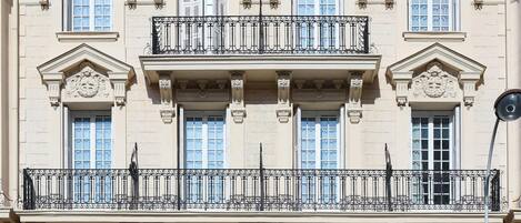 Un immeuble à plusieurs étages, doté de balcons décorés et de grandes fenêtres.