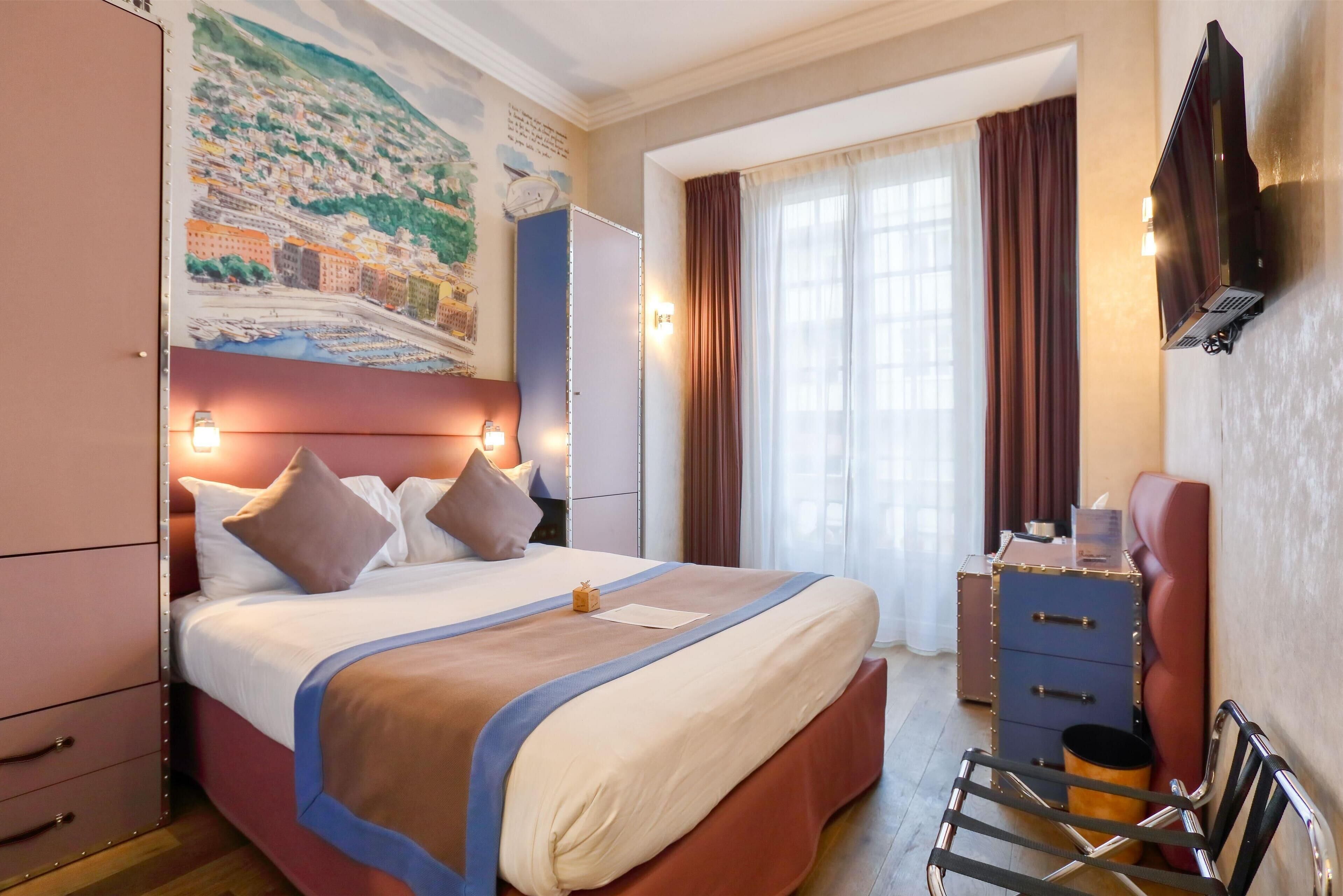 A hotel room with a large bed, a wardrobe, a desk, and a chair.