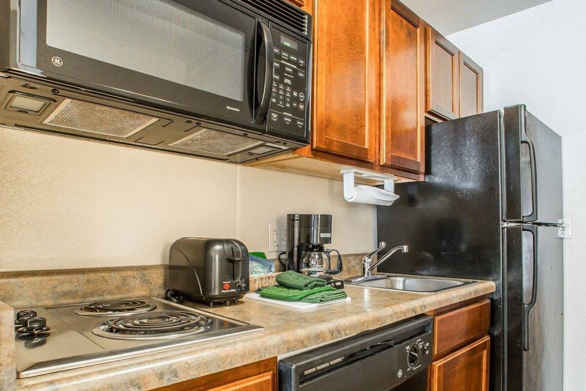 Una cocina equipada con microondas, tostadora, cafetera, lavaplatos, estufa y lavavajillas.