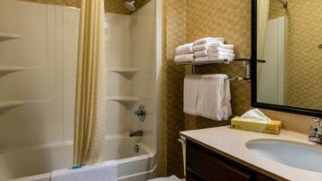 A bathroom with a bathtub, a toilet, a sink, and a mirror.