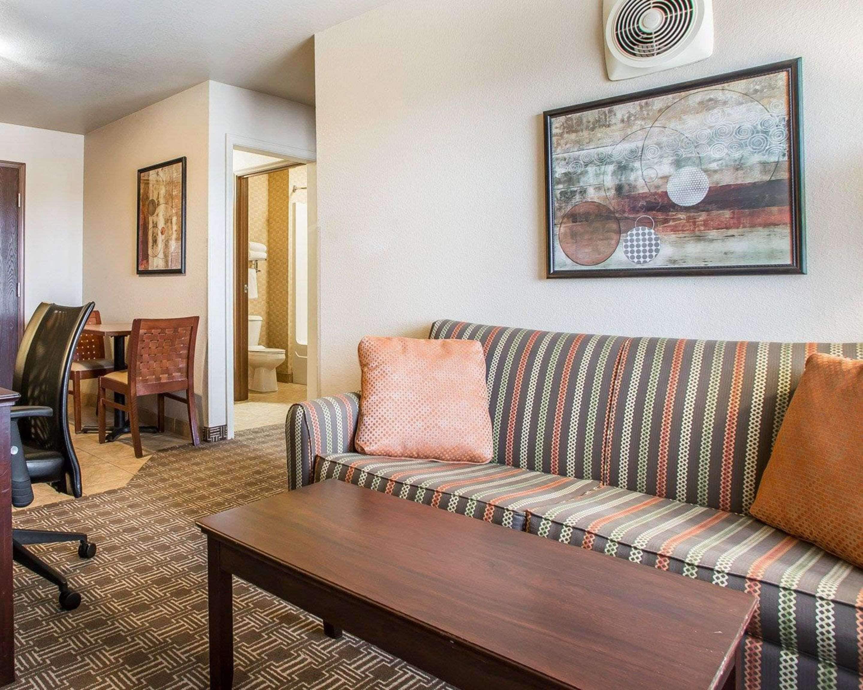 A living room with a sofa, a coffee table, and a dining area with chairs.