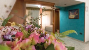 A room with a teal accent wall, a wooden door, and a framed picture. - Hotel Residence Arcobaleno (Palmi)