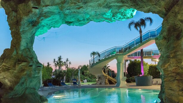 A pool area with a glass bridge and palm trees. - Hotel Residence Arcobaleno (Palmi)